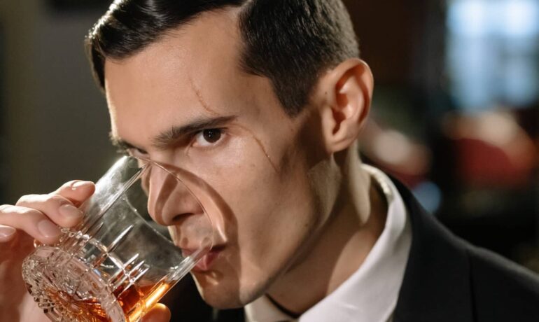 Bărbat care adulmecă o expresie de whisky